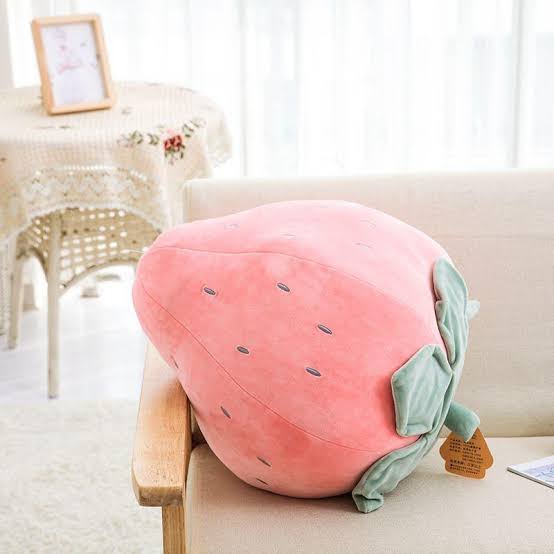 Kawaii strawberry shaped plushies in red and green on a shelf